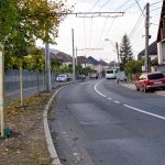 Stradă rezidențială cu autobuz, mașini și trotuare noi