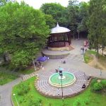 Foișor și fântână arteziană într-un parc verde