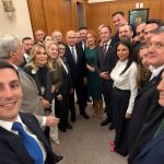 Grup de persoane în ținută formală, într-un birou cu lambriuri