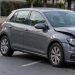 Mașină gri avariată în partea frontală după accident