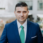 Bărbat în costum albastru și cravată verde