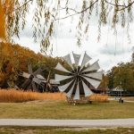 Două mori de vânt într-un parc cu vegetație autumnală