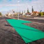 Pistă verde pentru biciclete lângă o intersecție urbană