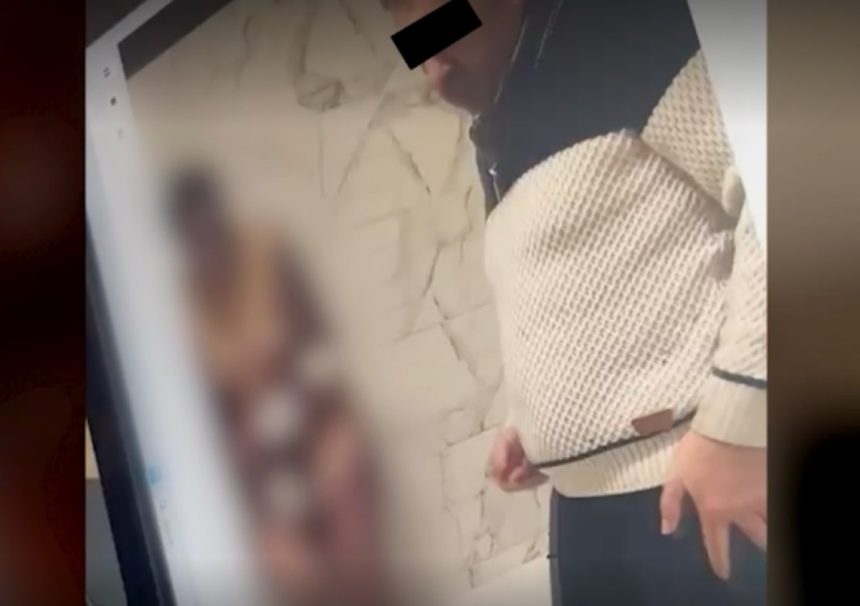 Persoană cu fața acoperită privind ecranul unui telefon