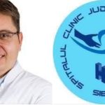 Medic lângă sigla Clinicii Județene de Urgență Sibiu