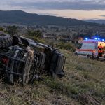 ATV răsturnat pe deal, lângă ambulanță și paramedici
