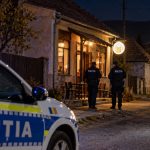 Polițiști lângă un local, noaptea, în sat