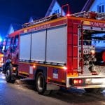 Autospecială de pompieri intervenind noaptea pe o stradă